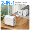 A white 2-in-1 power adapter with two USB ports is shown on a wooden table.