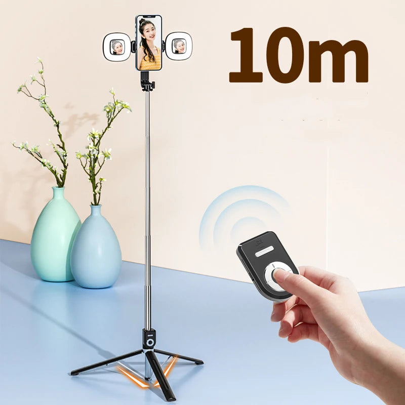 A hand holds a tripod with an attached phone camera, LED ring light, and mirror, demonstrating its 10-meter extension capabil