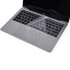 A clear TPU keyboard cover is placed on a silver MacBook laptop.