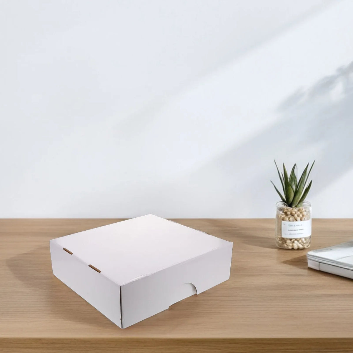 Caja portátil de tarjetas con múltiples compartimentos blanca sobre una superficie de madera.
