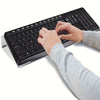 A hand is typing on a black keyboard placed on a clear acrylic stand.