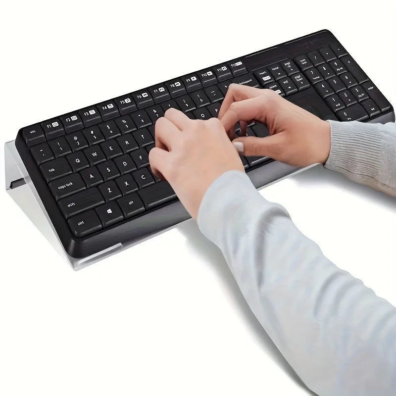 A hand is typing on a black keyboard placed on a clear acrylic stand.