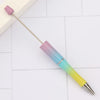 A DIY beadable pen set with a purple and iridescent gradient body and silver tip resting on a white surface.