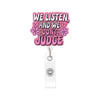 A pink badge reel featuring text that reads We Listen and We Don't Judge surrounded by floral designs.