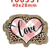 A pink plaid heart shape with the word love written in black script on a natural wood background.