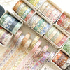 A collection of five rolls of floral washi tape in various patterns and colors displayed in cardboard boxes.