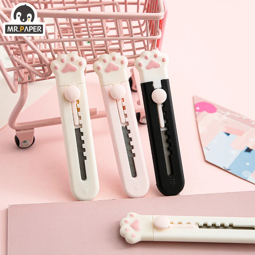Three pink and white portable pet claw tools or knives are displayed on a pink background.