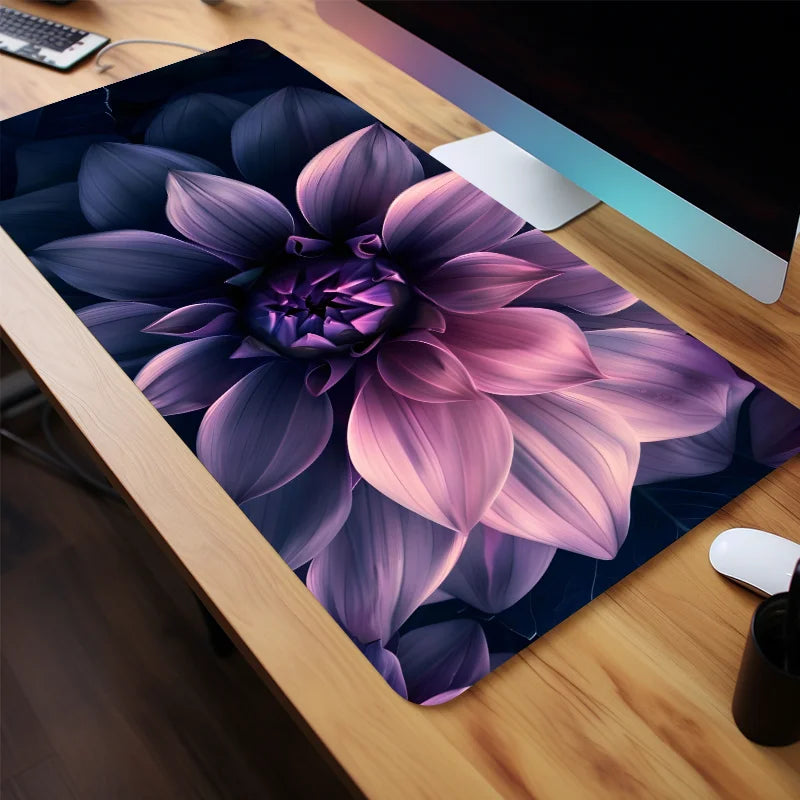 A close-up of an aesthetic floral mouse pad featuring purple and pink lotus flowers on a wooden desk.