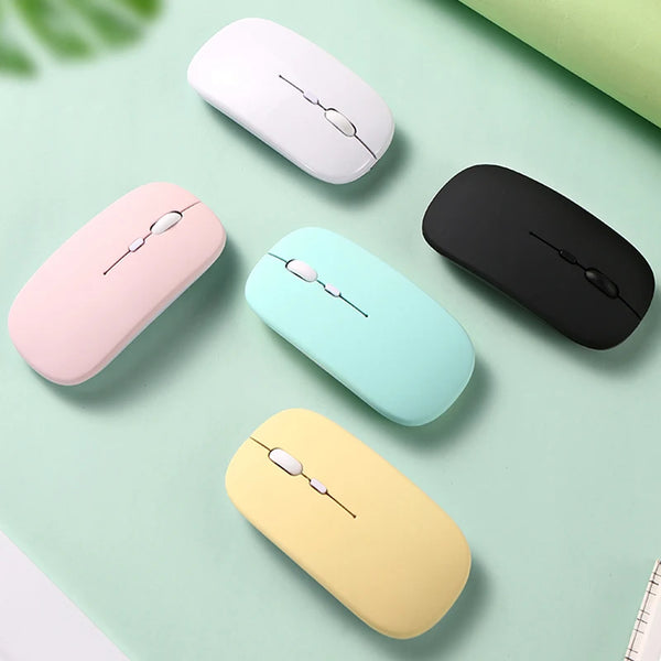 A collection of five silent wireless Bluetooth computer mice in pink, black, light blue, yellow, and white, arranged on a lig