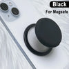 Black 360° magnetic phone grip stand with silicone cover placed on a white phone.