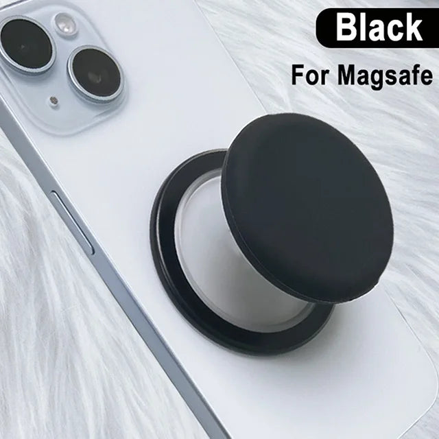 Black 360° magnetic phone grip stand with silicone cover placed on a white phone.