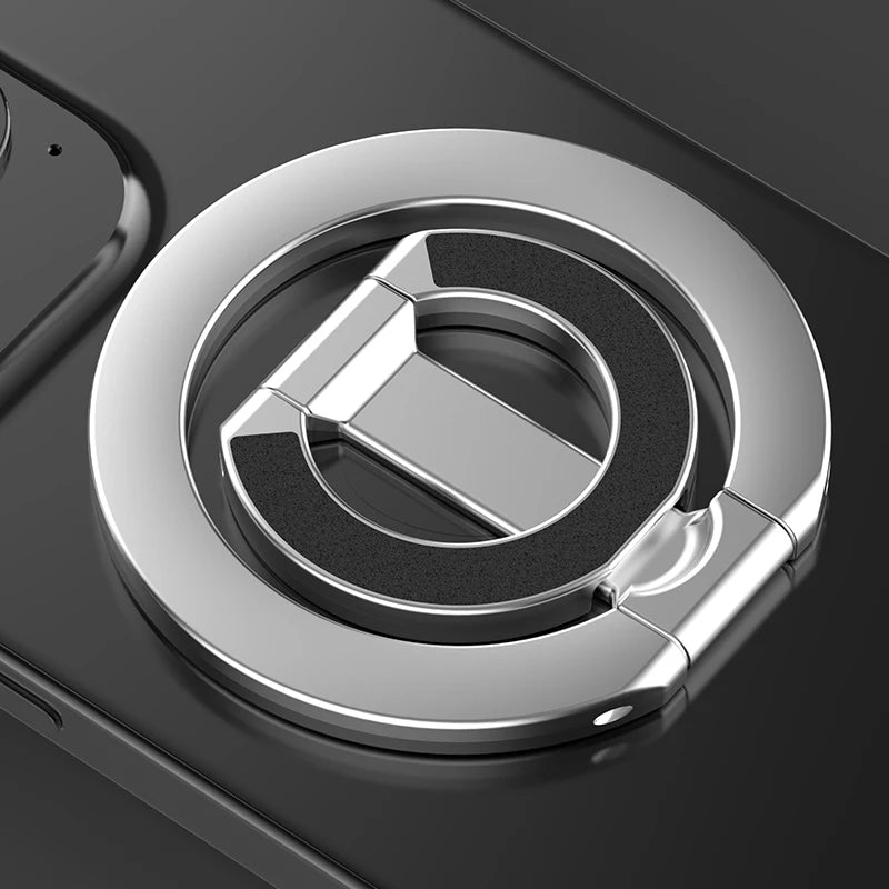 A close-up of a silver MagSafe double-sided phone ring holder on a dark surface.