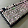 A close-up view of side-lit cherry profile mechanical keycaps arranged in a row on a black keyboard base.