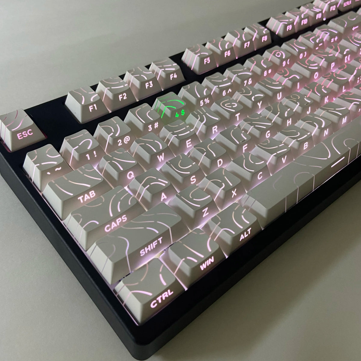 A close-up view of side-lit cherry profile mechanical keycaps arranged on a keyboard layout.