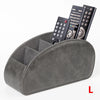 A gray PU leather caddy organizer holding three black TV remotes.