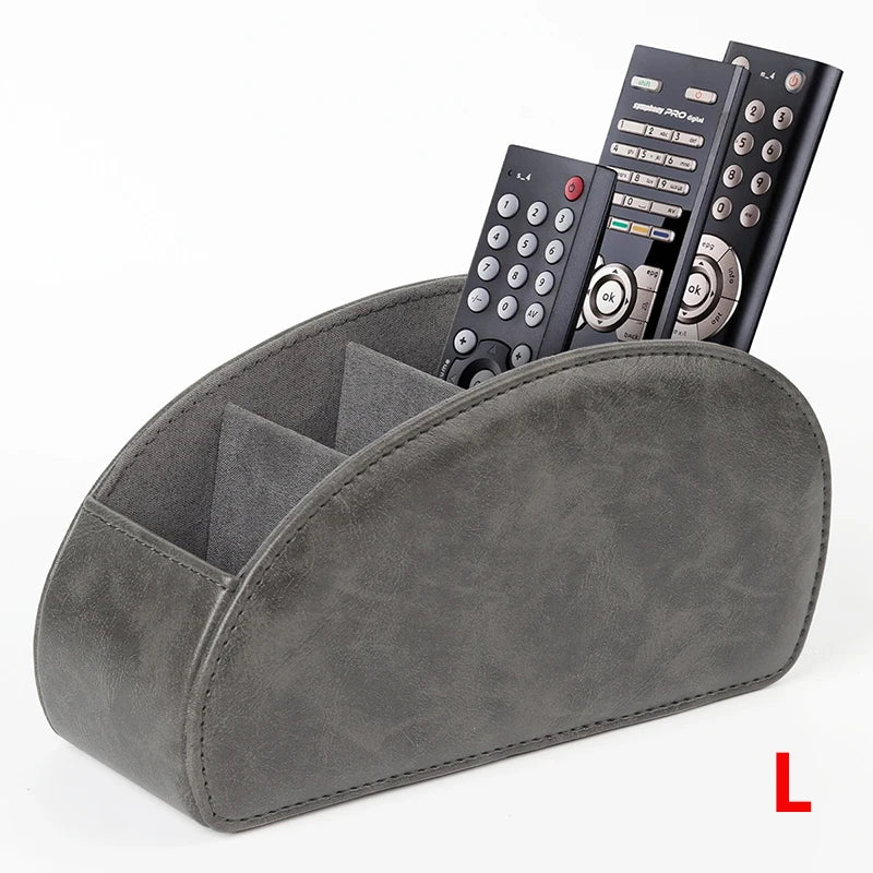 A gray PU leather caddy organizer holding three black TV remotes.