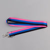 A pink, blue, and black striped vintage cassette tape lanyard with a metal clip.