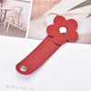A reddish-pink leather flower cable organizer with a silver stud, shown against a white background.