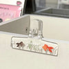 Frosted transparent book page clips featuring small fish and plant designs
