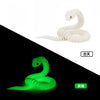 A white, articulated 3D printed snake figurine shown in daylight and nighttime settings.