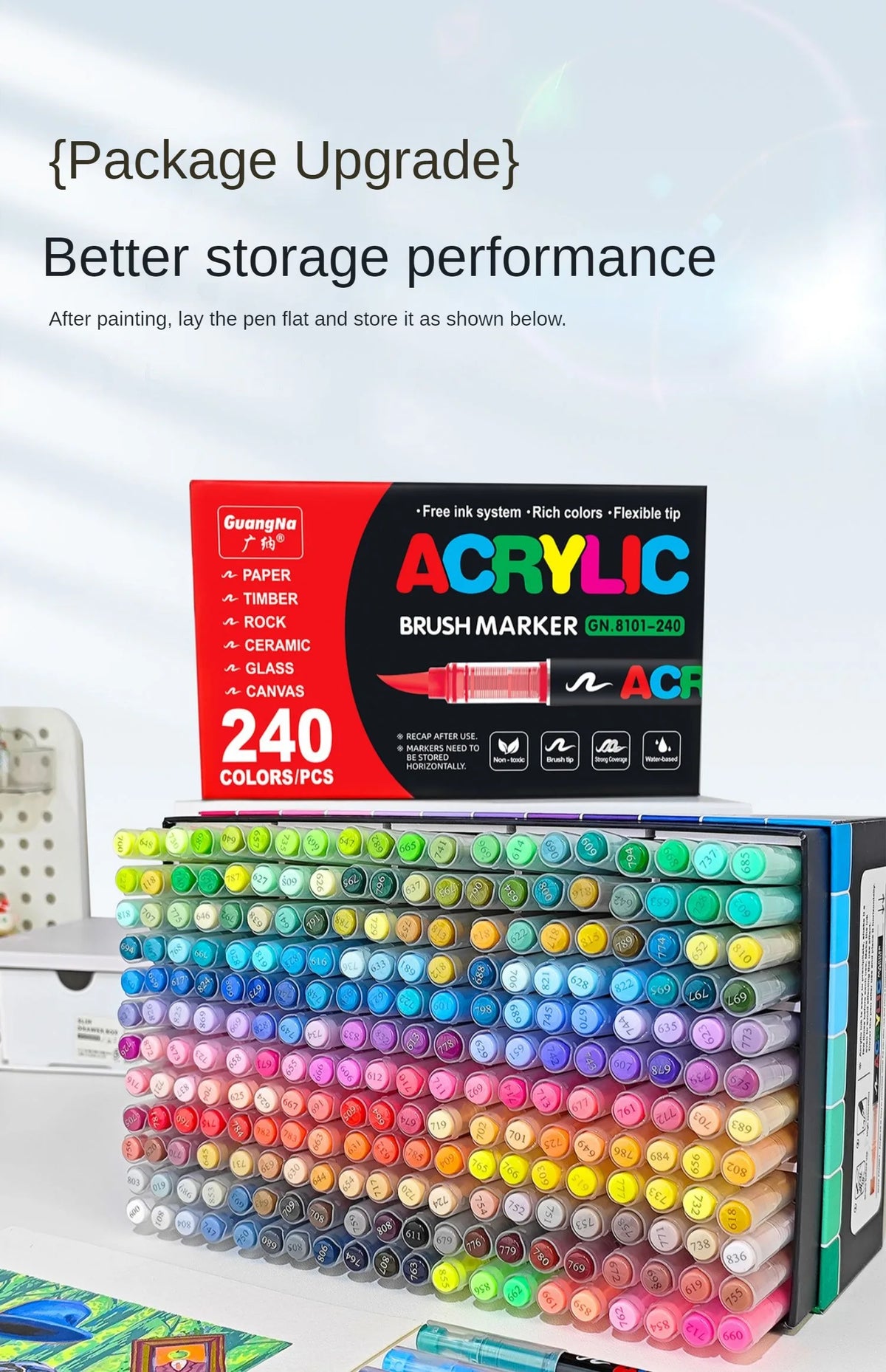 A box of acrylic brush markers and a large set of colorful paint pens are displayed on a white surface.