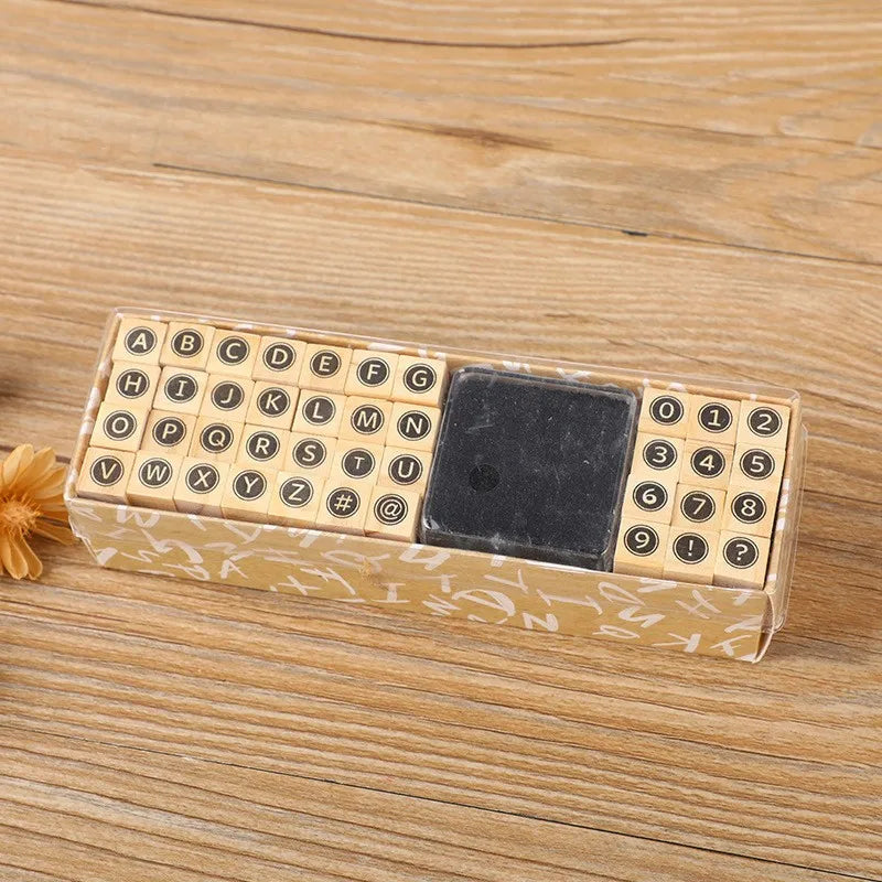 A wooden stamp seal set with alphabet and number stamps and a square stamp on a light brown background