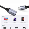 A black adapter connects a USB-C cable to various devices including computers, tablets, phones, cameras, and game consoles.