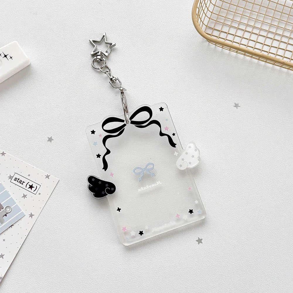 Clear acrylic card holder with a black bow and star charm attached to a silver keychain.