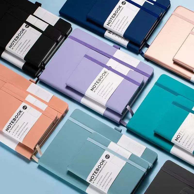 A collection of premium PU leather A5/A6 journal notebooks in various shades including black, blue, purple, pink, and teal.
