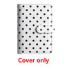 White leather binder cover with black polka dots and a clear elastic closure.