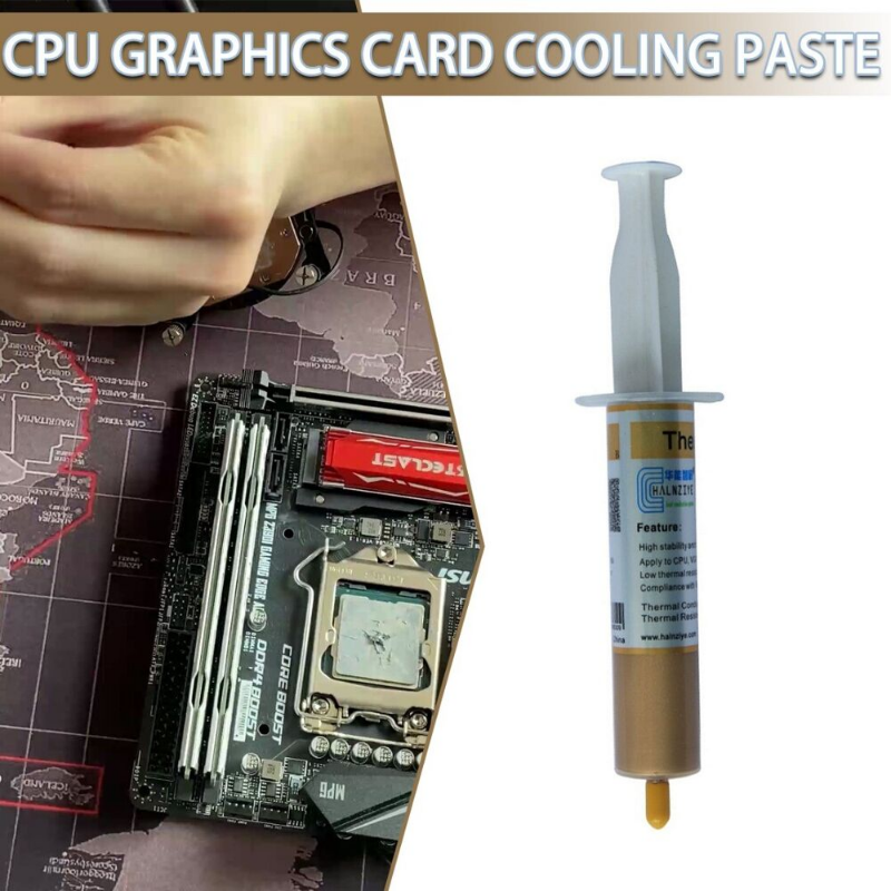 Ein Tube thermische Paste zum Kühlen von CPU und Grafikkarte neben einem Motherboard.