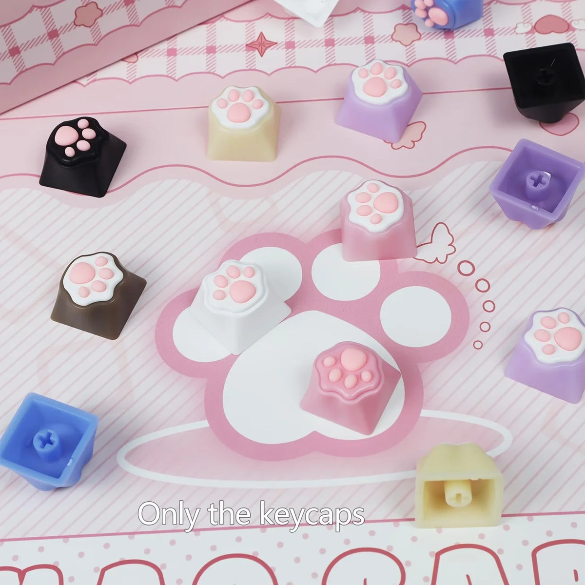 A collection of pink and purple kawaii cat paw and heart keycaps for MX switches displayed on a pink background.