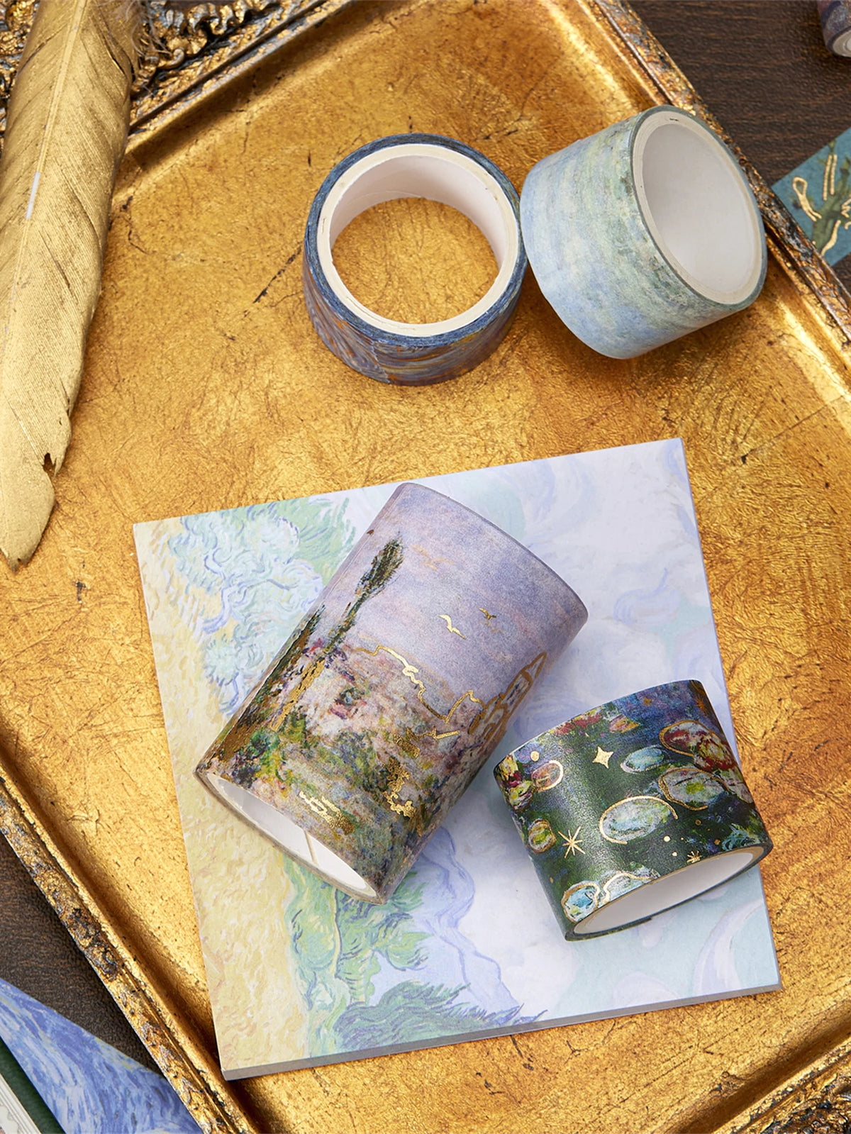 A set of oil painting themed decorative washi tape rolls displayed on a gold tray.