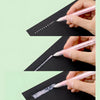 A hand uses a glue pen to apply white spot glue dots onto a black surface.