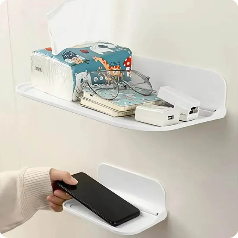 A white foldable wall shelf displaying various storage items including a box of glasses and a smartphone holder.