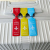 Five colorful durable PVC luggage tags in red, yellow, and blue are displayed on a white suitcase.
