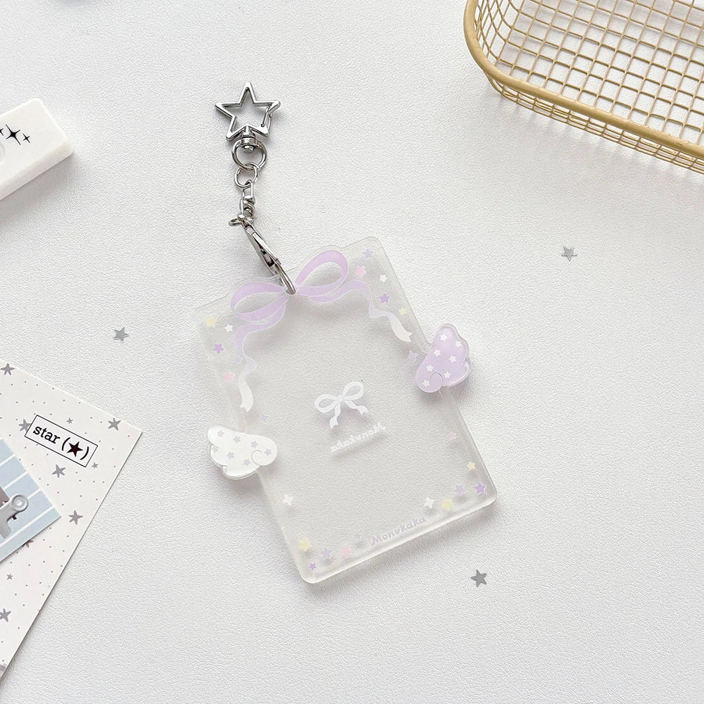Clear acrylic card holder with a purple ribbon and small decorative elements, attached to a silver keychain.