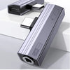 A silver audio adapter with a USB-C connector is shown resting on a white surface.