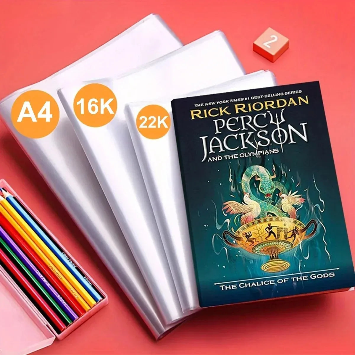 Pila de protectores transparentes para documentos A4 y 16K junto a un libro de Rick Riordan Percy Jackson