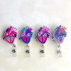 A set of four colorful anatomical heart diagram badge reels featuring pink and purple illustrations.