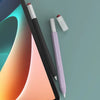 A black stylus pen with a silicone protective cover and a purple pen lying on a light blue-green background.
