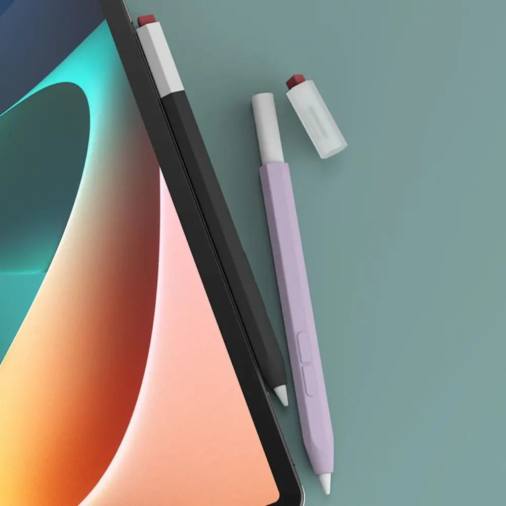A black stylus pen with a silicone protective cover and a purple pen lying on a light blue-green background.