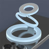 A white magnetic ring grip with a foldable kickstand shown on a dark surface.