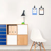 A white modern chair is positioned next to a wooden cabinet featuring storage compartments and two clipboards on the wall.