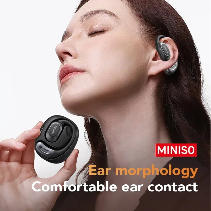 A woman is wearing a black open-ear wireless sports earbud in her ear, demonstrating comfortable ear contact.