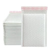 A stack of white bubble mailers with pink text indicating various adhesive removal instructions.