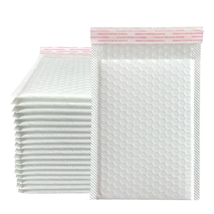 A stack of white bubble mailers with pink text indicating various adhesive removal instructions.