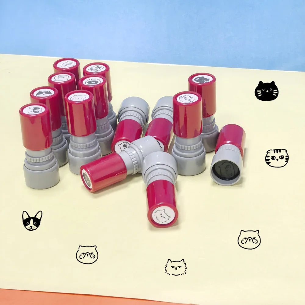 A collection of red and gray cat pattern stamps arranged on a light yellow surface.