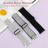 A close-up of a silver glitter nylon strap for an Apple Watch next to a black braided nylon strap.