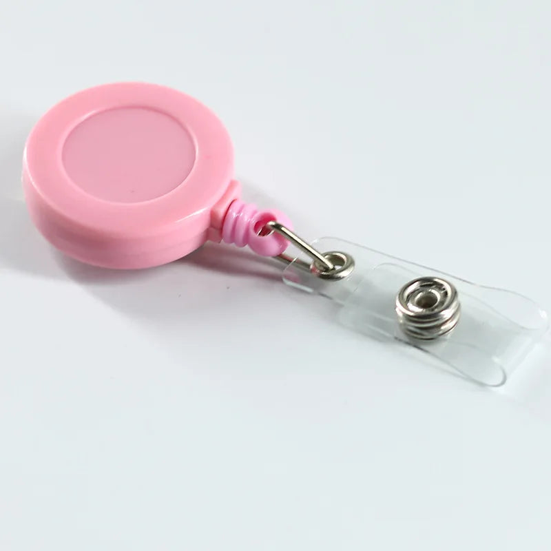 Porta credencial de plástico rosa con correa de plástico transparente y clip de metal.